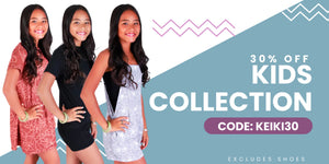 Three young women posing with a promotional banner for a kids' clothing collection sale. 30% off kids collections, excluding shoes. Use Code: KEIKI30