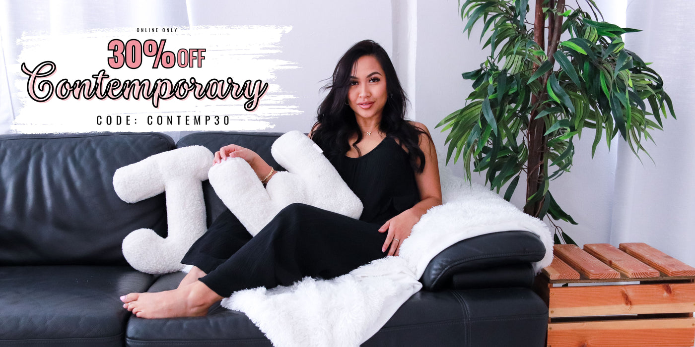Woman sitting on a couch with promotional text of 30% Off Contemporary Collection. Use Code: CONTEMP30
