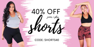 Two women wearing athletic wear with a promotional banner for 40% off junior and plus shorts on a pink background. Use Code: SHORTS40
