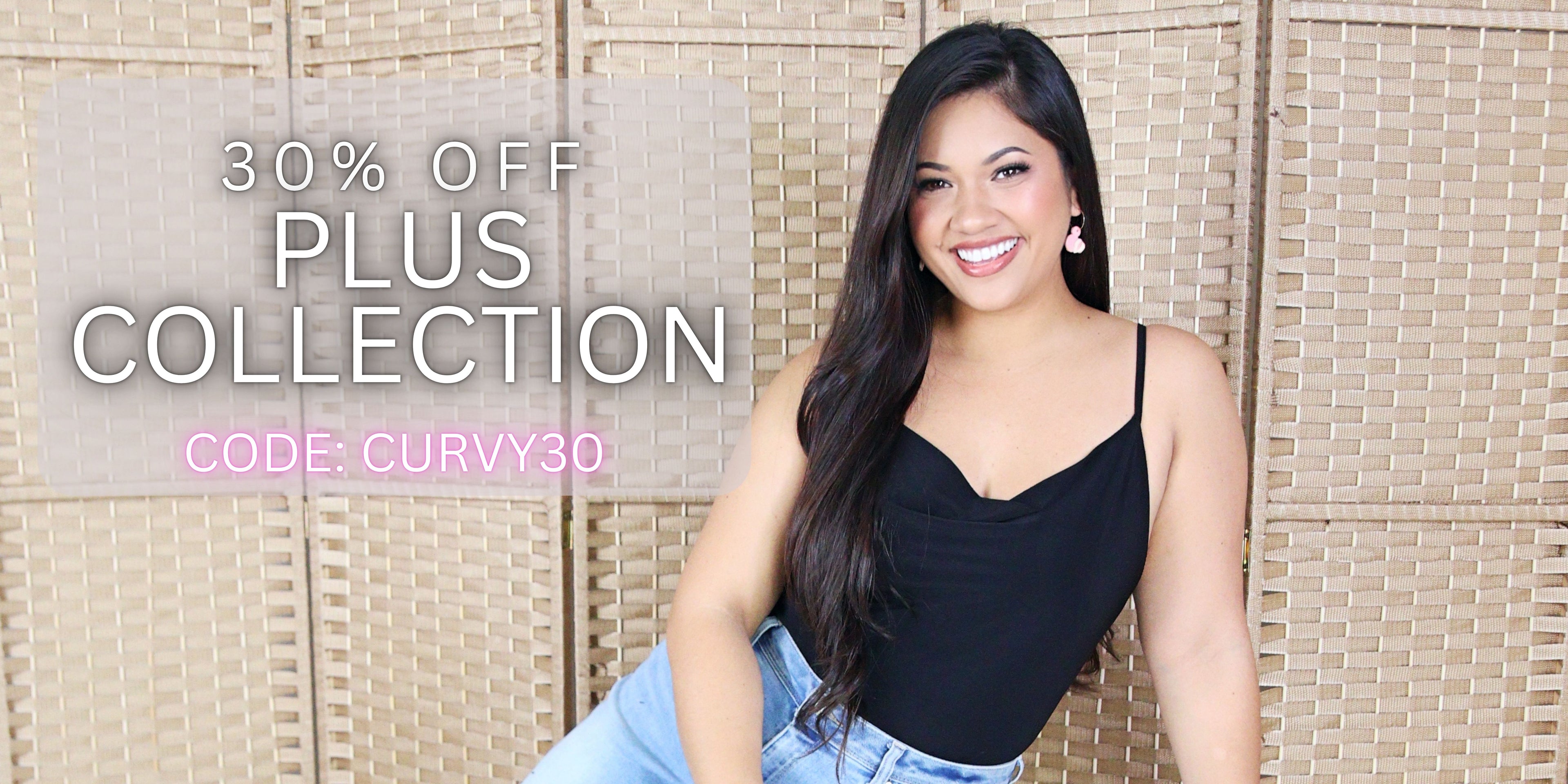 Woman in black top and jeans sitting against a woven wall with promotional text overlay. 30% off Plus collection, use code: CURVY30